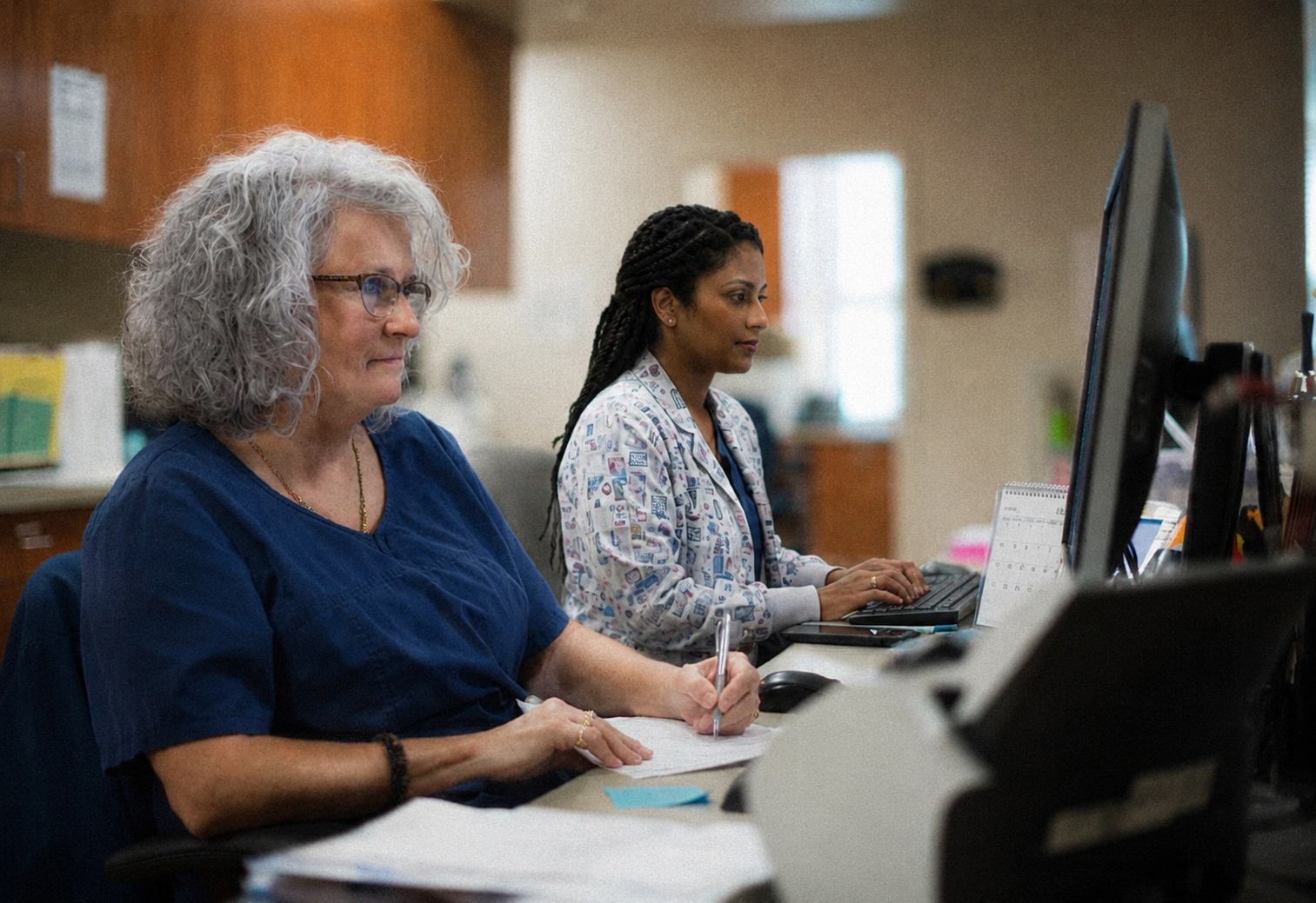 Front-desk billing staff working at a practice management workstation